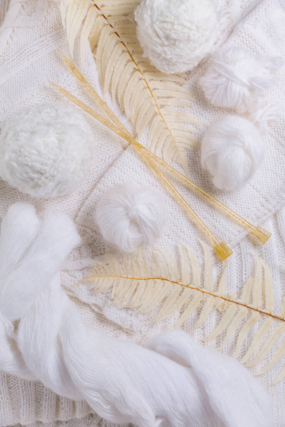 Концепция вязания с иголками, шерстью, свитером и пряжей белого цвета - Фото, изображение