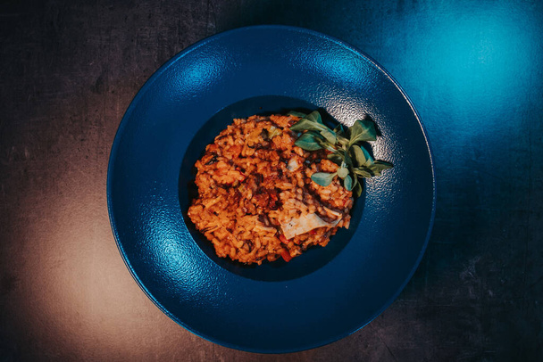 A closeup shot of pilaf with bacon and basil in a blue bowl - Fotografie, Obrázek