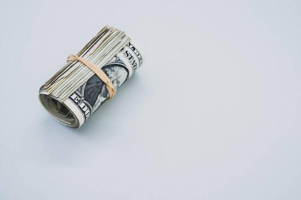 A high angle shot of rolled-up dollar bills on a blue surface - Φωτογραφία, εικόνα
