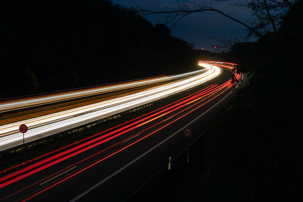 Μια όμορφη και πολύχρωμη μεγάλη έκθεση των αυτοκινήτων οδήγησης στην εθνική οδό τη νύχτα - Φωτογραφία, εικόνα