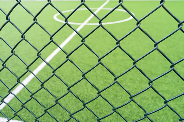 Kerítésháló közelkép egy focipálya hátteréről. - Fotó, kép