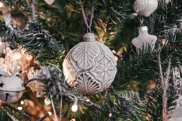 Un primo piano di bellissimi ornamenti d'argento su un albero di Natale festivo - Foto, immagini