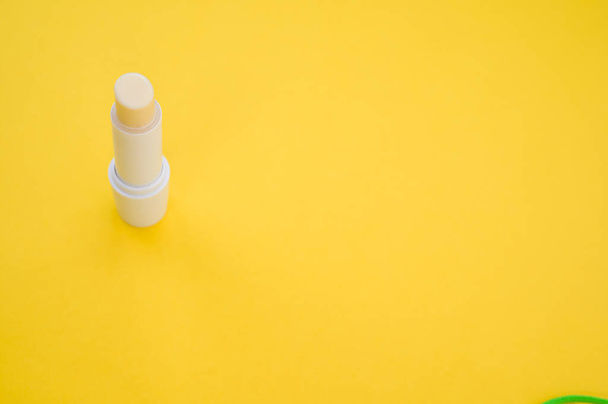 A closeup shot of a yellow lipstick isolated on a yellow background - 写真・画像
