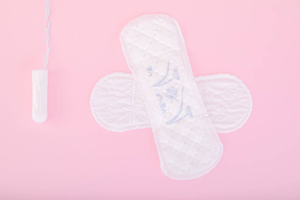 Everyday sanitary pads and a tampon on a pink background - Fotoğraf, Görsel