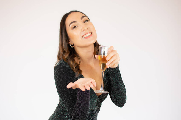 Buon anno a te. Una giovane e bella donna che balla con un bicchiere di champagne e sorride. La donna è felice per il nuovo anno - Foto, immagini