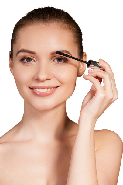 Woman holding make-up brush on eyebrow and smiling - Photo, Image