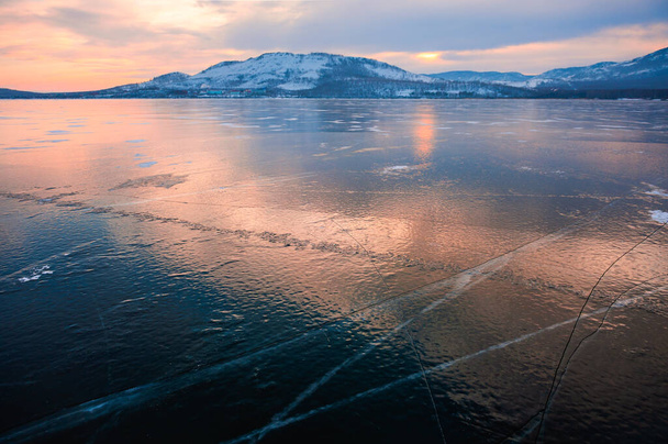 Ice on the frozen lake at sunset. Beautiful winter landscape. Bannoye lake in South Ural, Russia - Zdjęcie, obraz