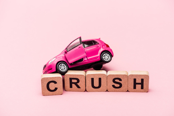 játék autó és szó összetörni kockák rózsaszín háttér - Fotó, kép