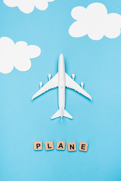 top view of airplane model and cubes with word plane on blue sky background - Фото, зображення