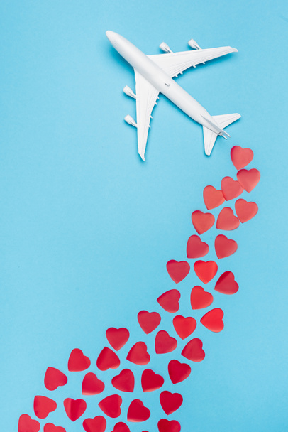 top view of plane model and red hearts on blue background - Fotoğraf, Görsel