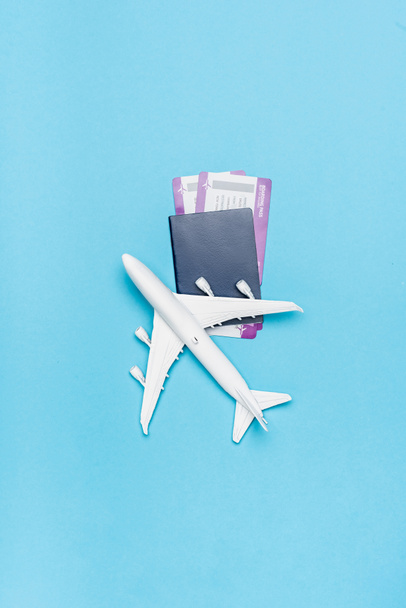 top view of white plane model and tickets on blue background - Foto, imagen
