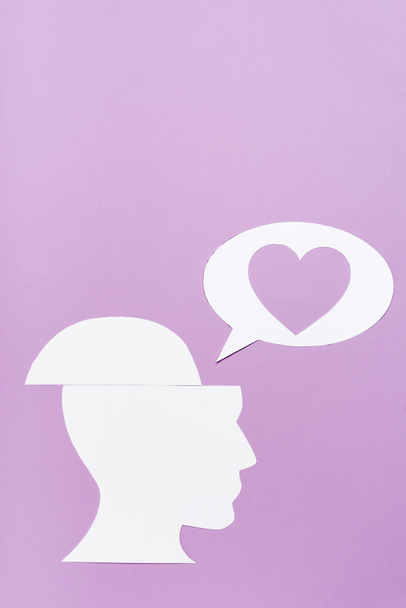 top view papír emberi fej és beszéd buborék szívvel lila háttér - Fotó, kép