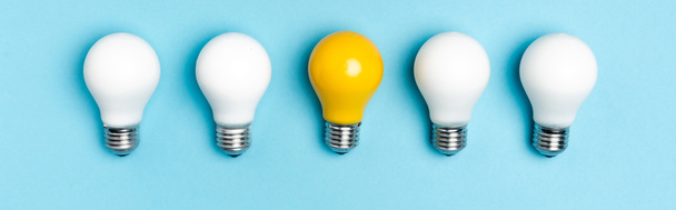 top view of white and yellow light bulbs on blue background, banner - Photo, Image