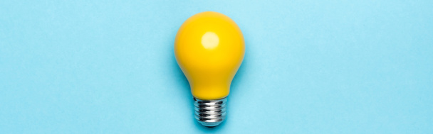 top view yellow light bulb on blue background, banner - Fotoğraf, Görsel