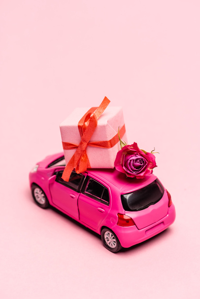 lelu auto ja lahja laatikko ruusu vaaleanpunainen tausta - Valokuva, kuva