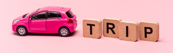 αυτοκίνητο και λέξη ταξίδι σε κύβους σε ροζ φόντο, πανό - Φωτογραφία, εικόνα