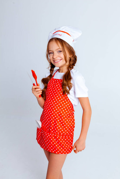 дівчина в шапці шеф-кухаря і фартух для приготування їжі
 - Фото, зображення