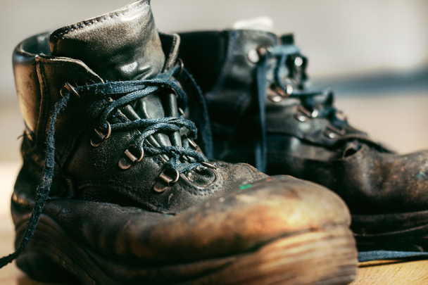 Anciennes bottes de travail usées avec laçage. Chaussures en cuir qui nécessitent une réparation ou un remplacement. Gros plan - Photo, image
