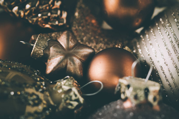 Close-up van decoratie voor de kerstboom in harmonisch donker brons, gouden en zilveren kleuren, selectieve focus op een ster - Foto, afbeelding
