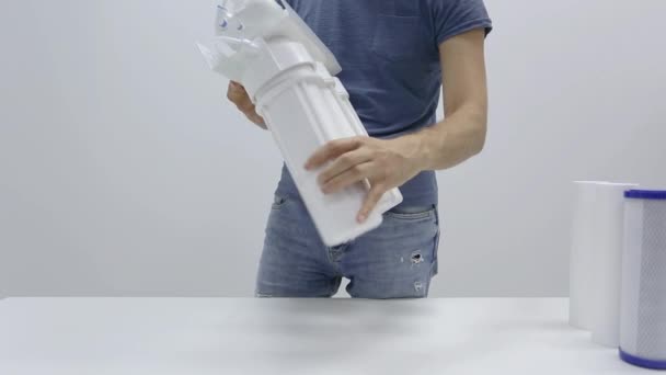 Мужские руки водопроводчика откручивают цилиндры бытового обратного осмоса водяного фильтра с частично проницаемой мембраной - Кадры, видео