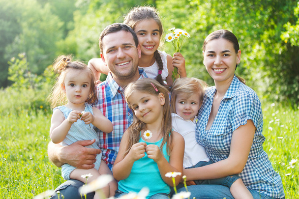 Щаслива молода сім'я з чотирма дітьми на відкритому повітрі
 - Фото, зображення