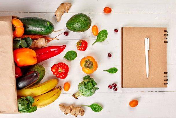 Flat lay saco de compras de papel com variedade de legumes e frutas frescas, conceito de supermercado de alimentos lista de compras, bio saudável, alimentos orgânicos no fundo branco, estilo de supermercado, mercearia, dieta vegetariana. - Foto, Imagem