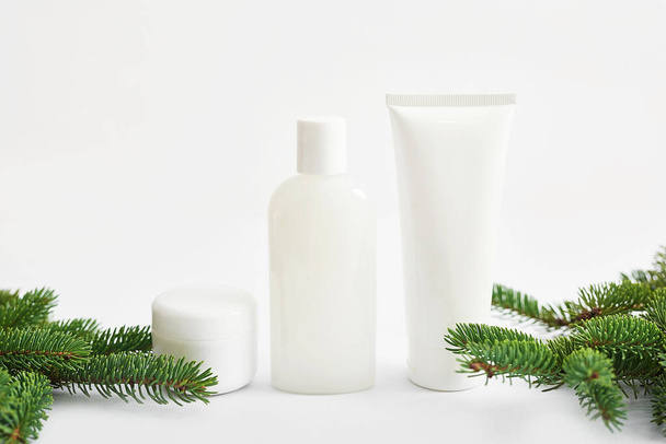 クリスマス美容化粧品販売の背景。白い背景に化粧品やモミの枝とフラットレイアウト組成。スキンケア&スパ製品。スペースのコピー - 写真・画像