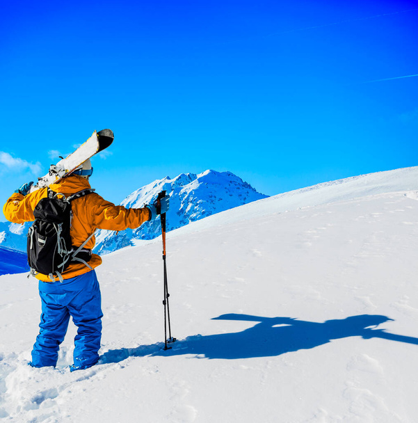 Ski in winter season, mountains and ski touring man on the top in sunny day in France, Alps above the clouds - Photo, Image