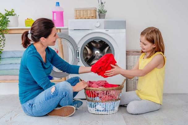 Mother with daughter near washing machine - Foto, immagini