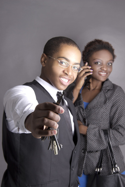 Young business couple excited while holding a key, smiling - Photo, Image