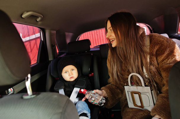 Young mother and child in car. Baby seat on chair. Safety driving concept. - Zdjęcie, obraz