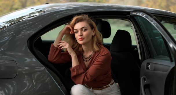 灰色の車に座っているスタイリッシュな女性 - 写真・画像
