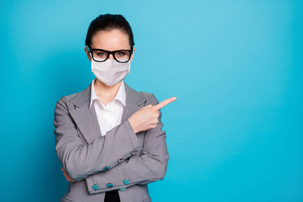 Portrait of attractive lady demonstrating copy space decision advert advice wear mask isolated over bright blue color background - Foto, afbeelding