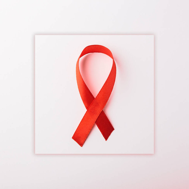 Red bow ribbon symbol HIV, AIDS cancer awareness with shadows, studio shot isolated on white background, Healthcare medicine concept, World AIDS Day - Фото, зображення