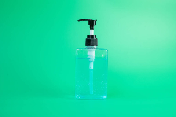 wash hand sanitizer gel bottle against coronavirus or Corona Virus Disease (Covid-19) at green background. Antiseptic, Hygiene, New Normal and Healthcare concept - Foto, imagen