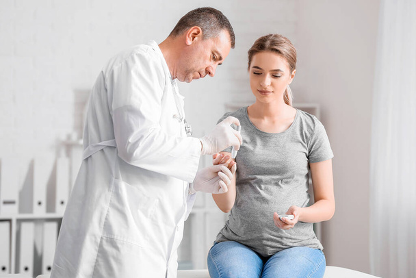 Pregnant diabetic woman visiting doctor in clinic - Foto, afbeelding