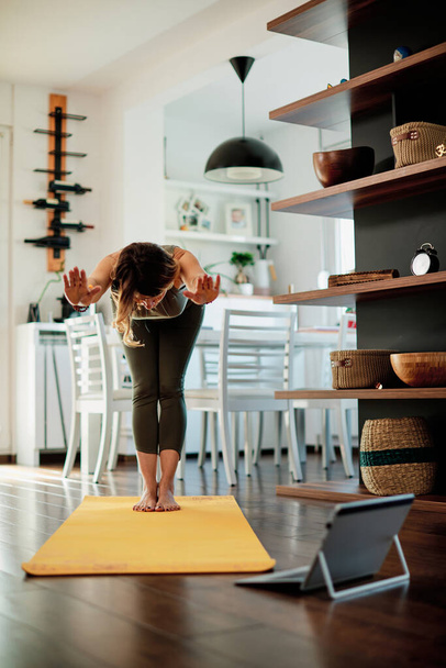 Mujer yogui de mediana edad haciendo yoga en casa. - Foto, Imagen