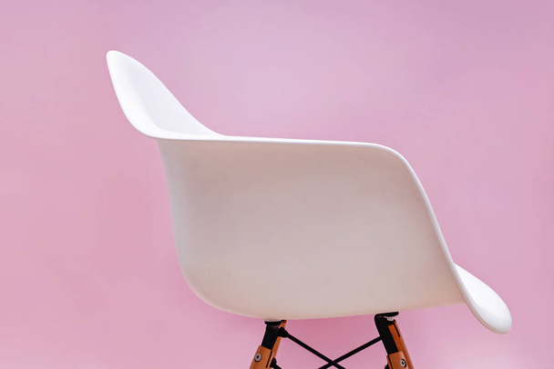 Bílá moderní židle přes růžovou stěnu. - Fotografie, Obrázek