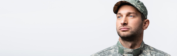 seriózní voják v uniformě a čepici izolované na bílém, prapor - Fotografie, Obrázek