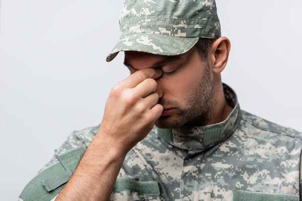 triste militaire en uniforme et casquette essuyant larmes isolé sur blanc - Photo, image