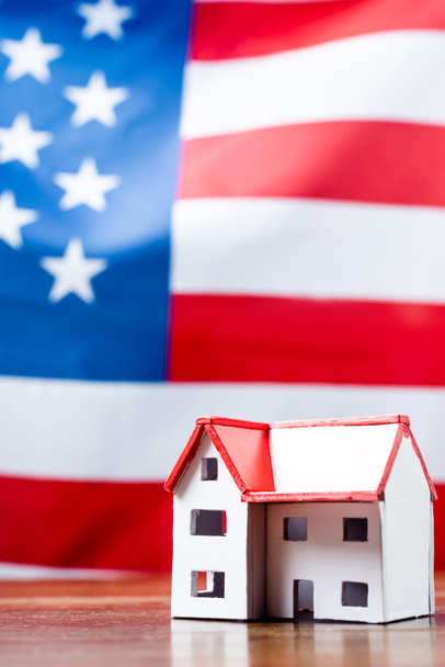 ház modell közelében amerikai zászló homályos háttér - Fotó, kép
