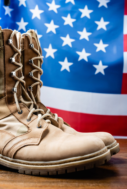 military boots near american flag on blurred background - Foto, afbeelding