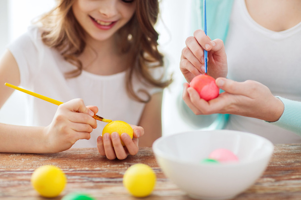 Close up of little girl and mother coloring eggs - Фото, зображення