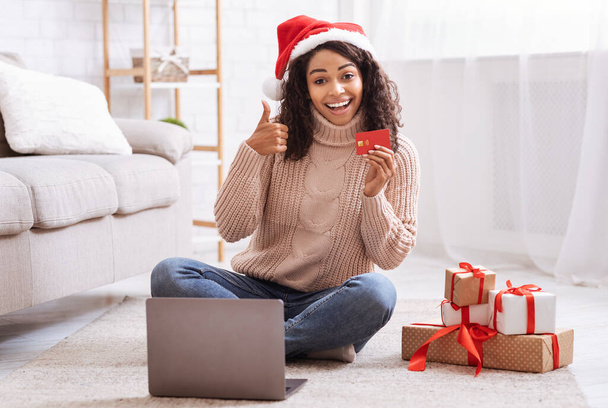 Karácsonyi vásárlás. Fekete hölgy használja laptop gazdaság hitelkártya - Fotó, kép