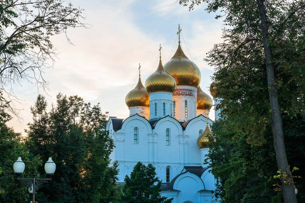 Rusland, Jaroslavl, juli 2020. De vergulde koepels van de orthodoxe kerk verlicht door de ondergaande zon. - Foto, afbeelding