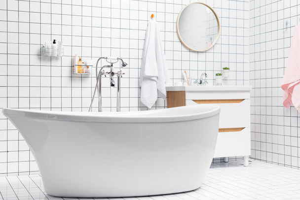 Interior de baño blanco con bañera y artículos de tocador  - Foto, Imagen