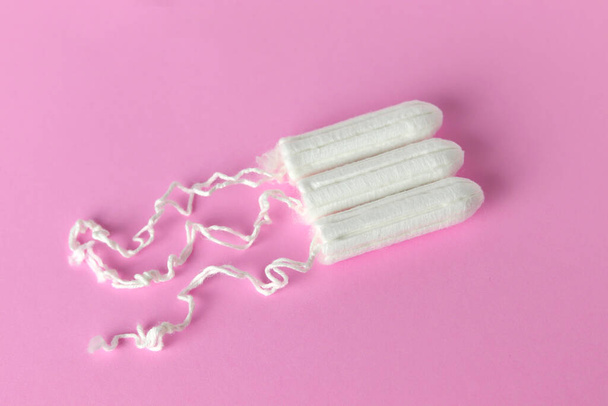 Medical female tampon on a pink background. Hygienic white tampon for women. Cotton swab. Menstruation, means of protection. Tampons on a red background. - Fotografie, Obrázek