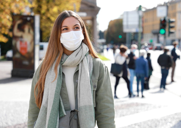 COVID-19 Social Distancing Woman in city street φορώντας χειρουργική μάσκα κατά του ιού της νόσου SARS-CoV-2. Κορίτσι με μάσκα προσώπου περπατά σεβόμενη την κοινωνική απόσταση κατά τη διάρκεια της Πανδημίας της νόσου του Coronavirus 2019. - Φωτογραφία, εικόνα