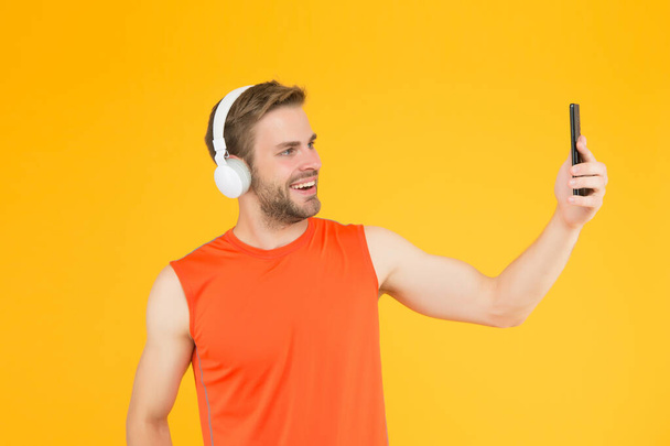 happy young man in sportswear wear modern headphones listening music while training use smartphone for selfie, digital sport - Photo, Image