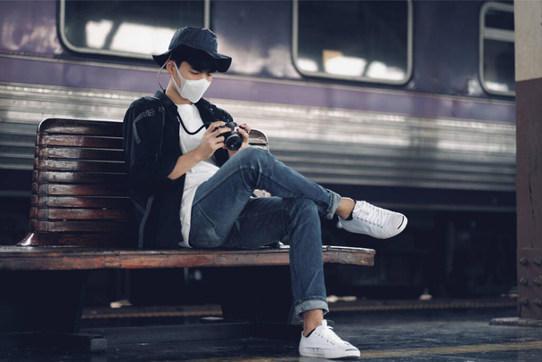 Uomo asiatico utilizzando smartphone con maschera medica per proteggere il Covid-19, nuovo stile di vita normale - Foto, immagini